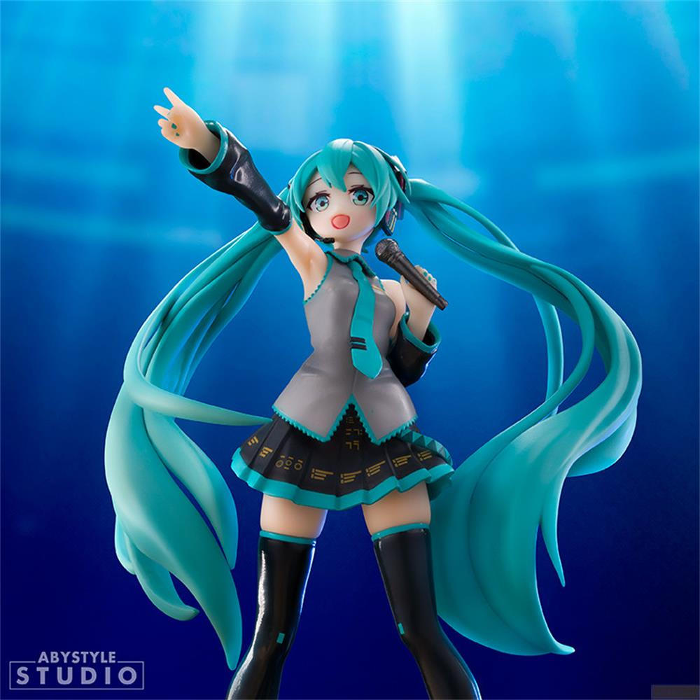 Figur von Hatsune Miku mit Mikrofon und blauen Haaren, vor blauem Hintergrund.
