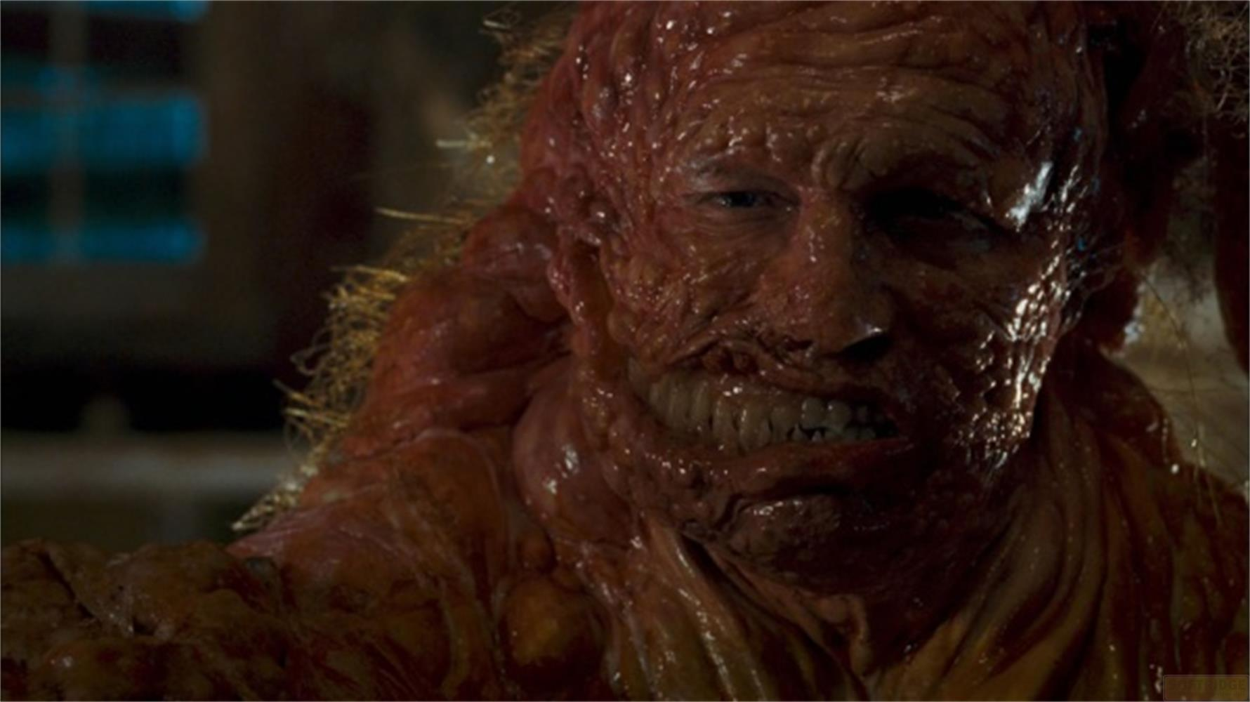 Une créature grotesque et charnue avec des dents et des cheveux visibles.
