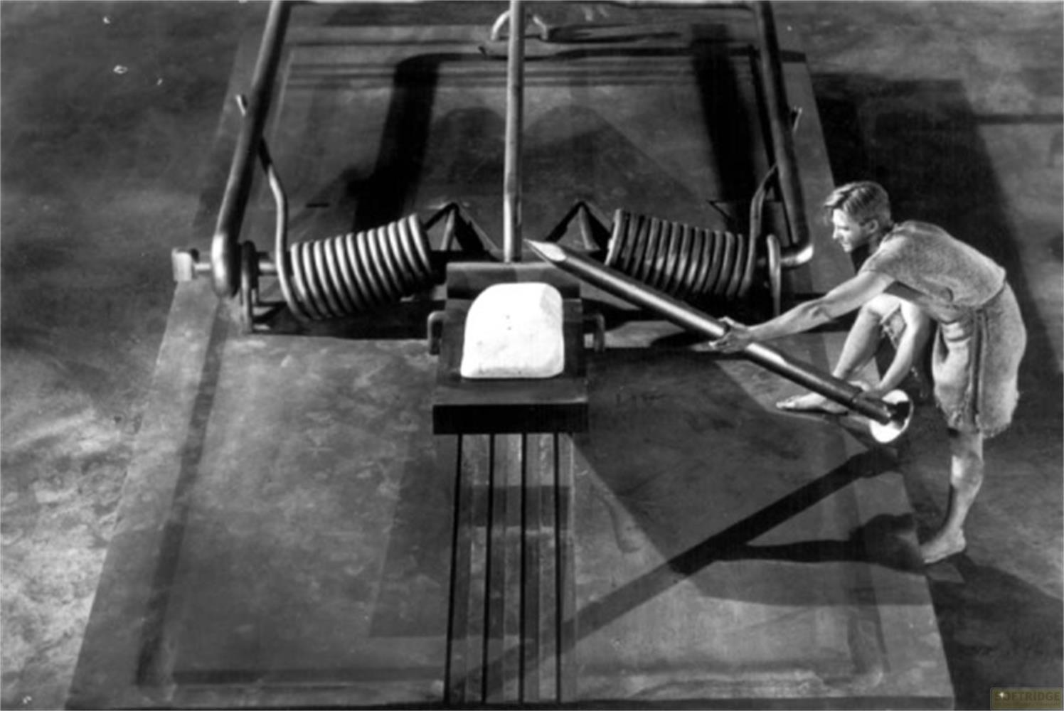 Un homme avec des barres pousse sur un piège tenant un objet blanc.