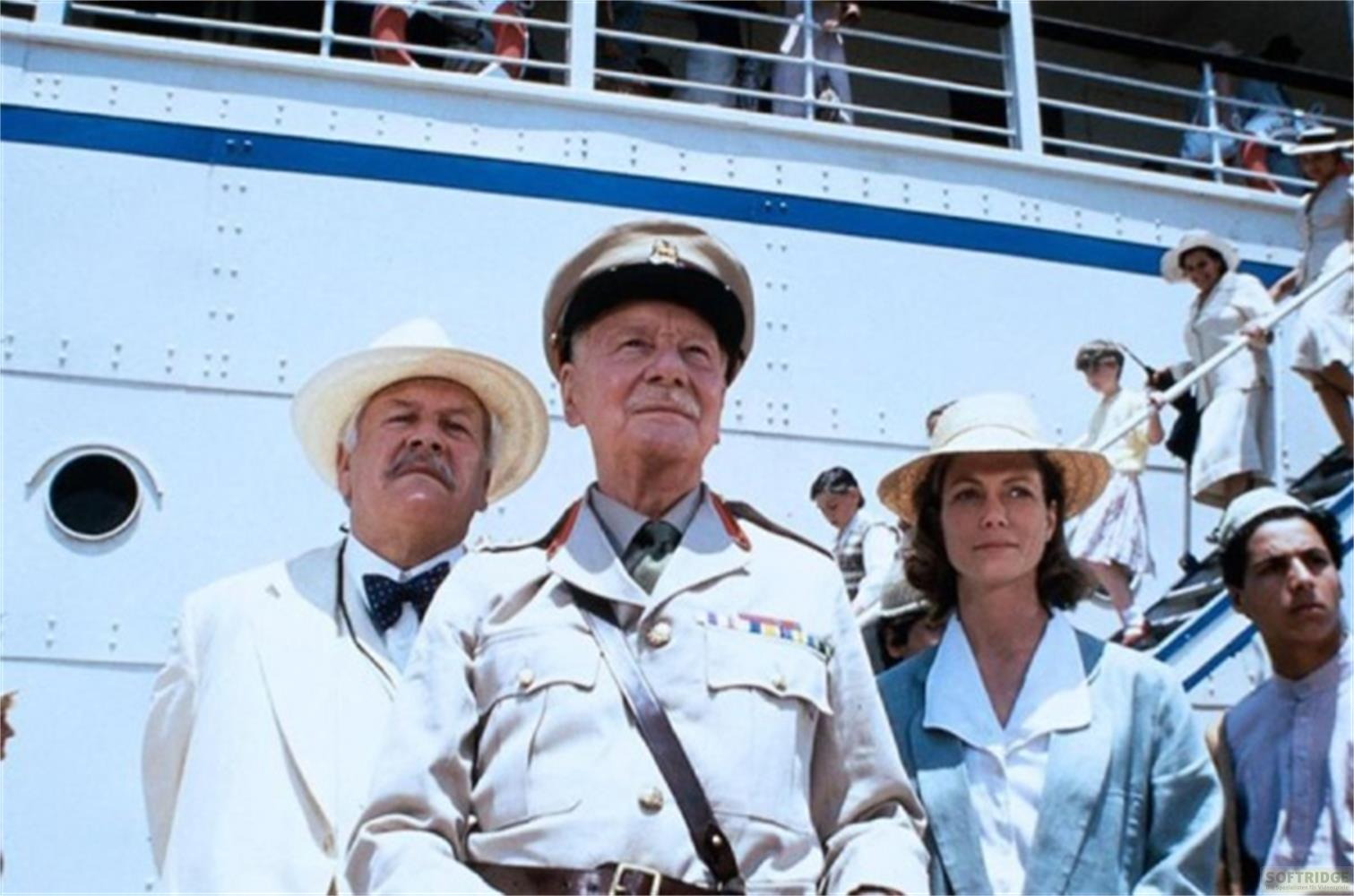 Tre persone davanti a una nave. Un uomo in uniforme, un uomo con cappello e una donna con cappello.