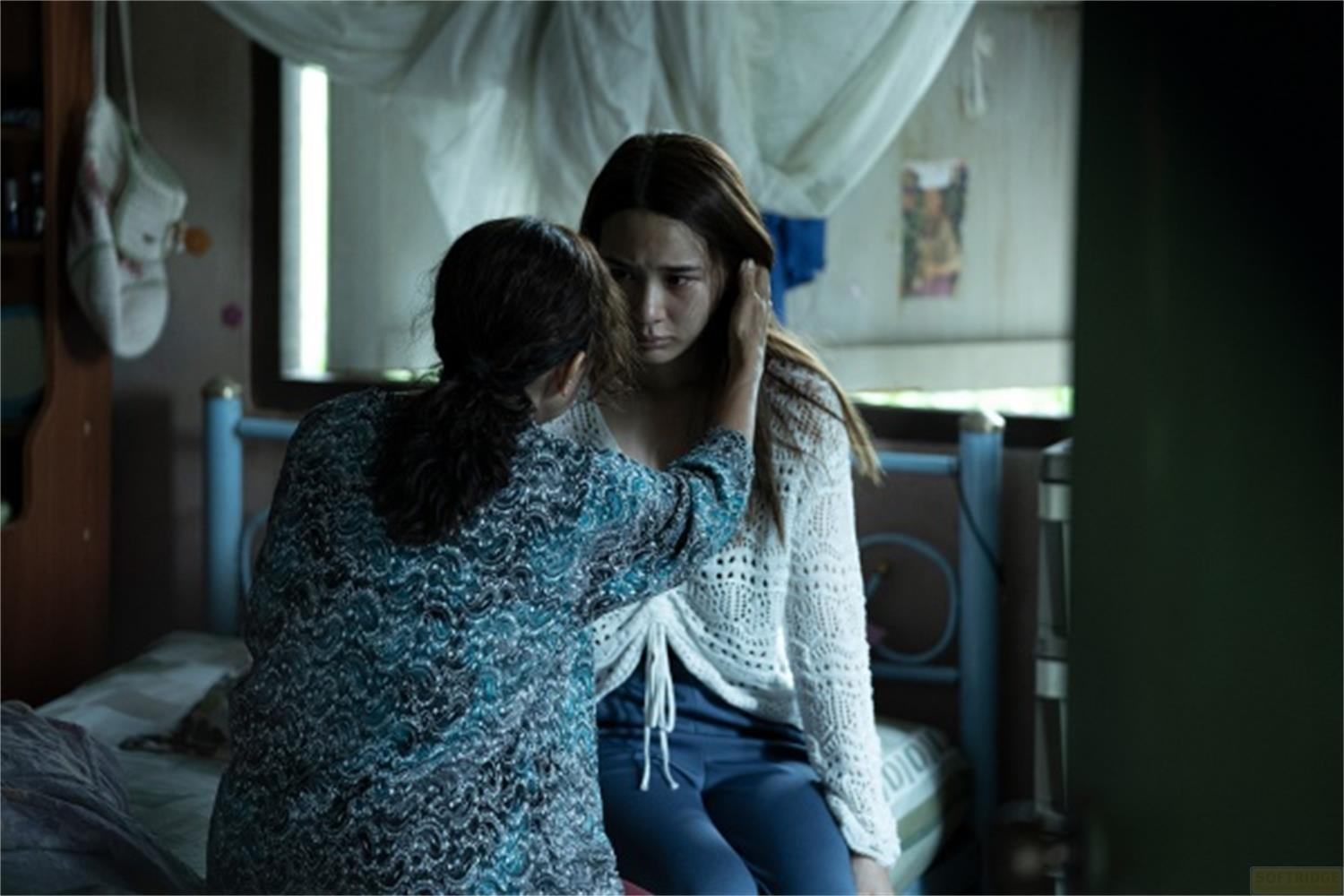 Una donna le mette una mano sulla guancia, lei sembra triste.