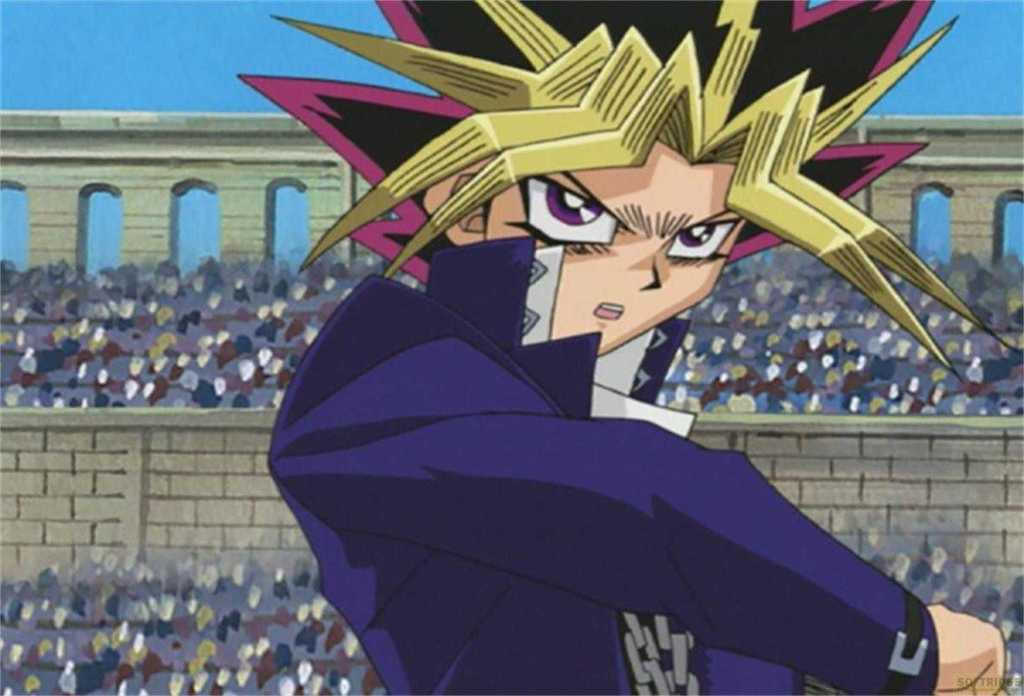 Yugi Muto in un cappotto blu si trova davanti a una folla in uno stadio.