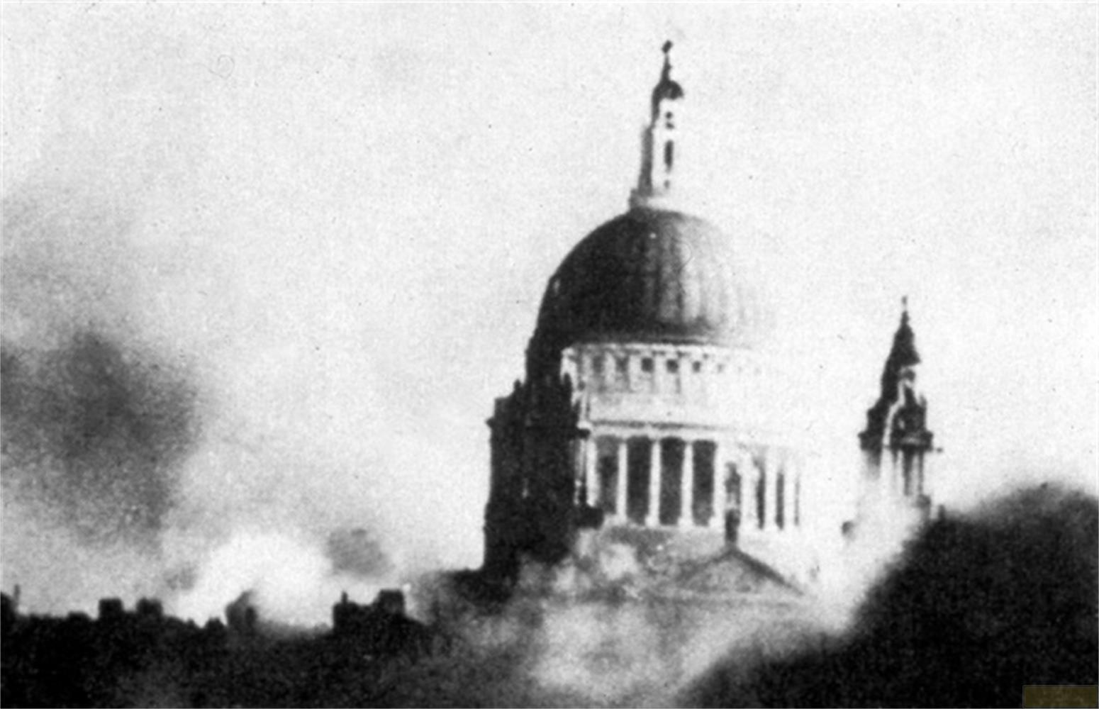 La Cattedrale di San Paolo emerge dal fumo, con contorni di edifici in primo piano.