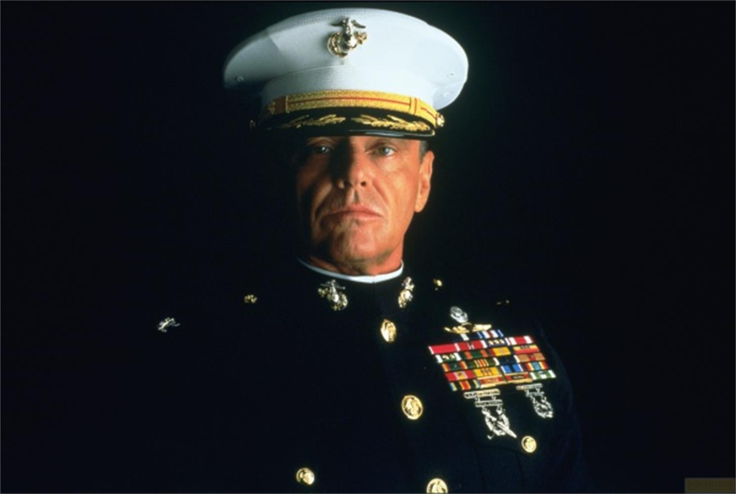 Un homme en uniforme de Marine, avec un chapeau et des médailles, sur fond sombre.