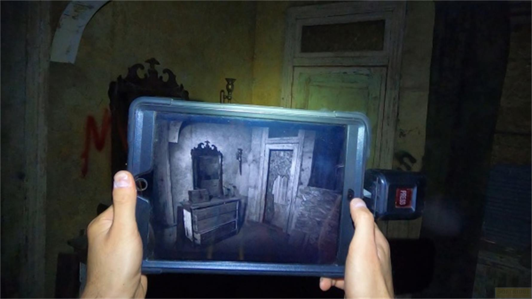 Una persona tiene in mano un tablet che mostra l'interno di un appartamento buio e spettrale.