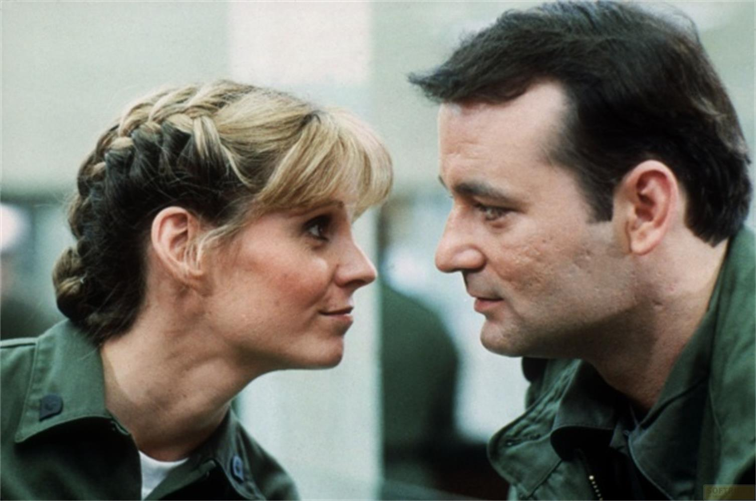 Un homme et une femme en vestes vertes se regardent.
