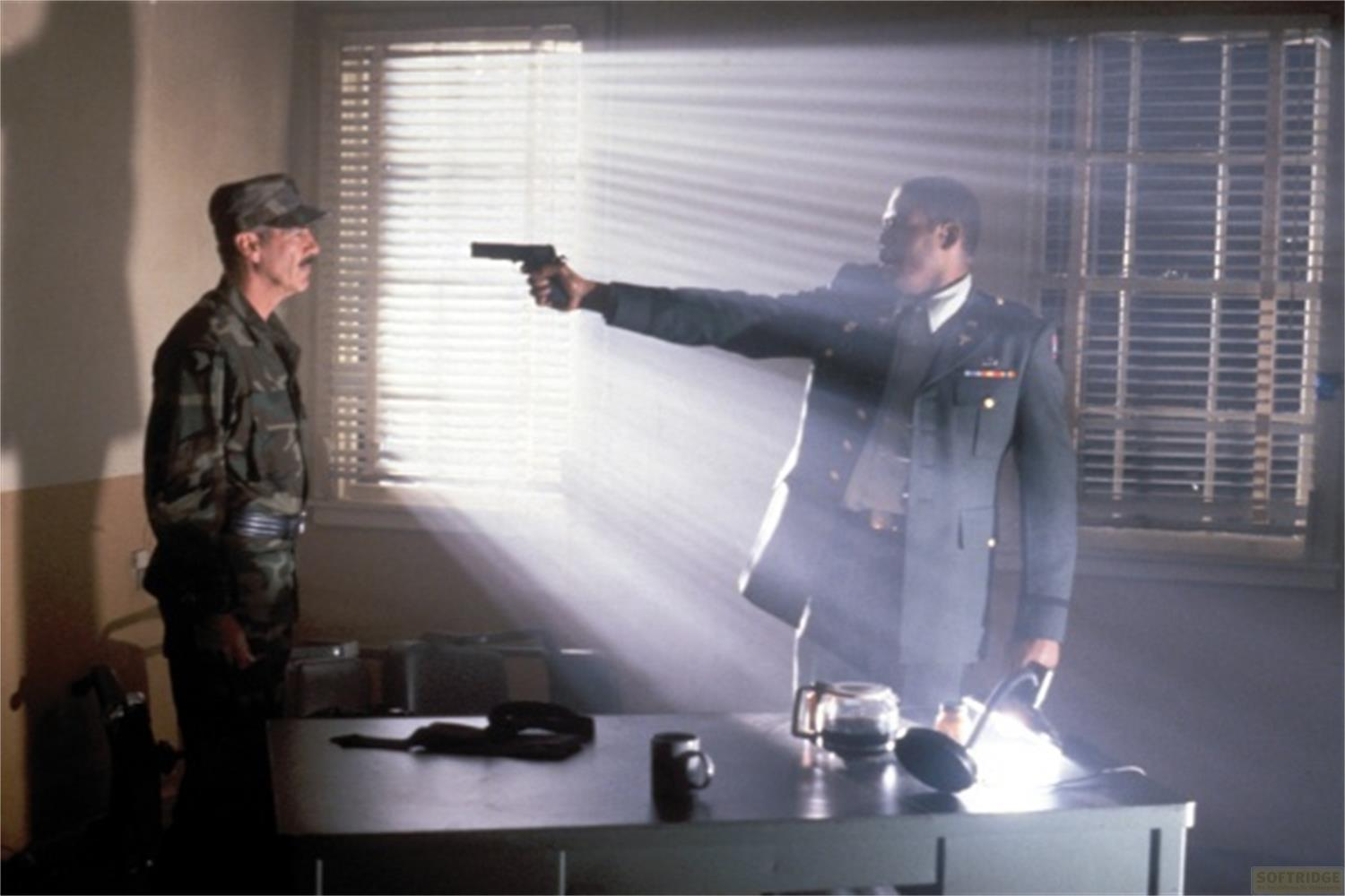 Un soldato in mimetica affronta un altro in uniforme che tiene una pistola.