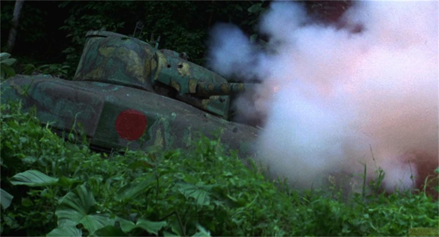 Un carro armato mimetizzato spara, con fumo che si alza, circondato da lussureggiante vegetazione verde.