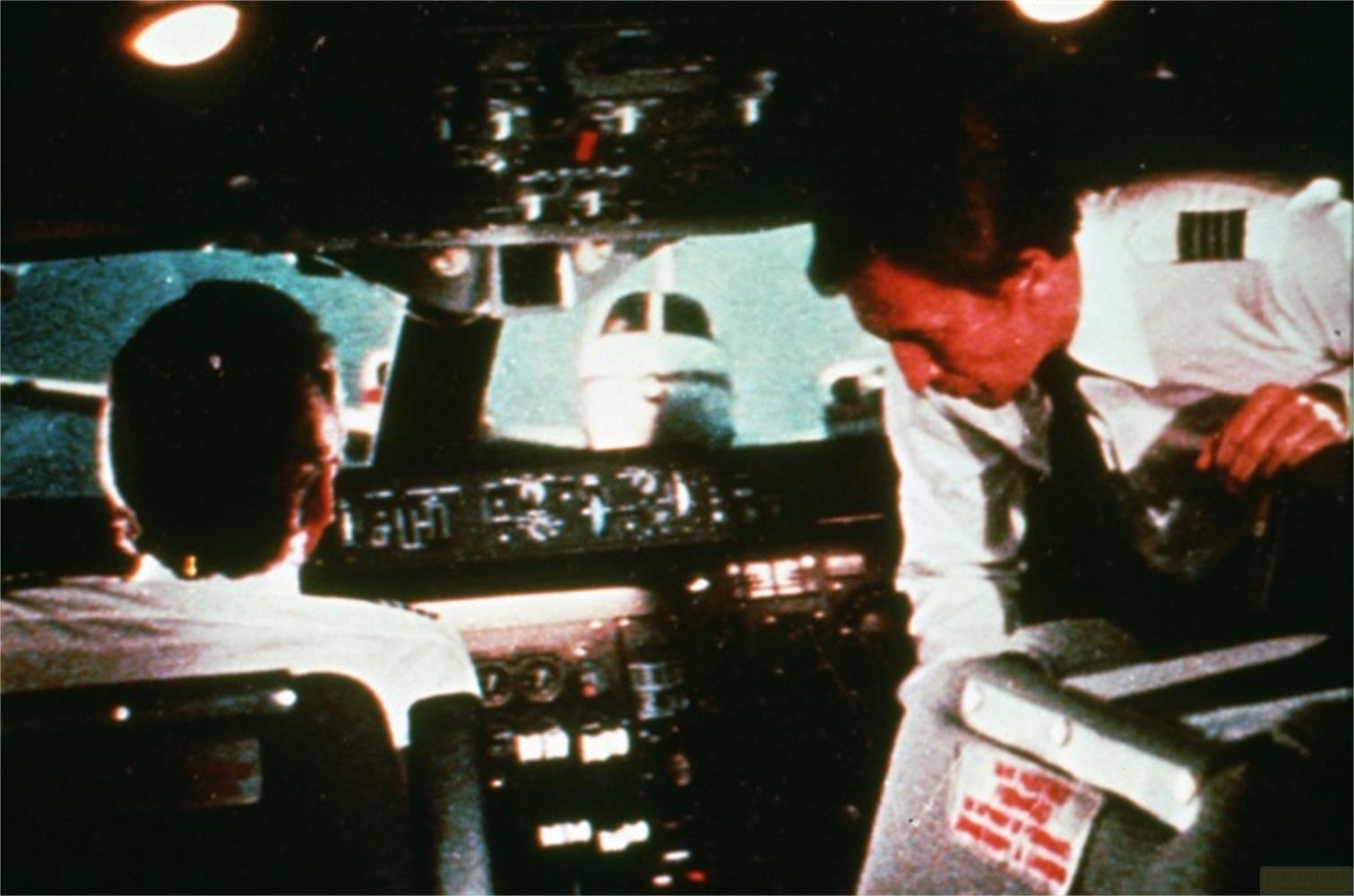 Zwei Piloten im Cockpit eines Flugzeugs blicken auf die Instrumente.