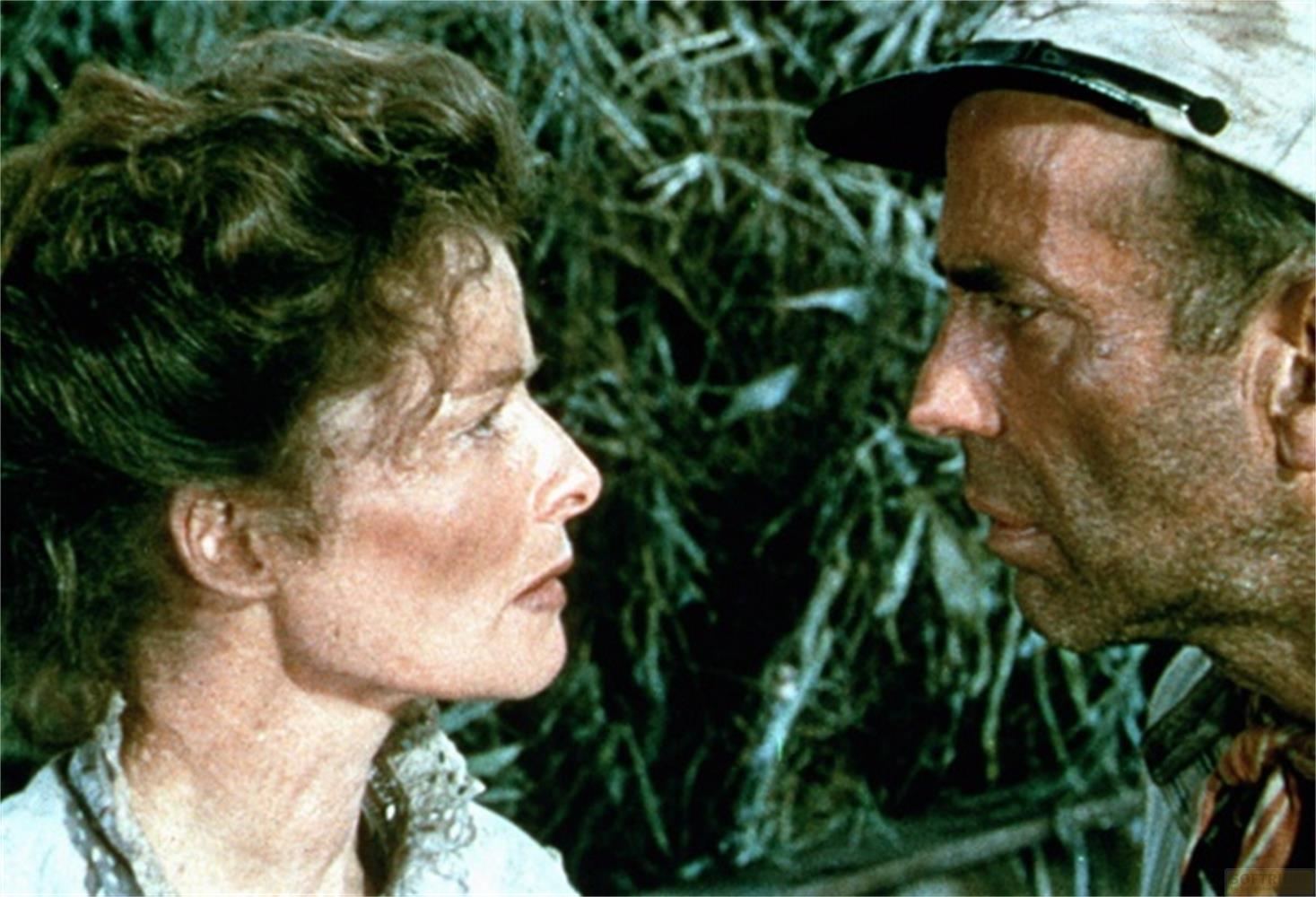Primo piano di una donna e un uomo di profilo, che si guardano tra il fogliame.