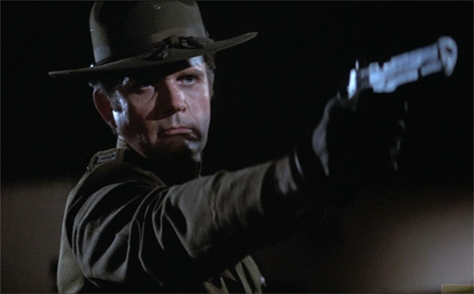 Un uomo con cappello e uniforme tiene una pistola.
