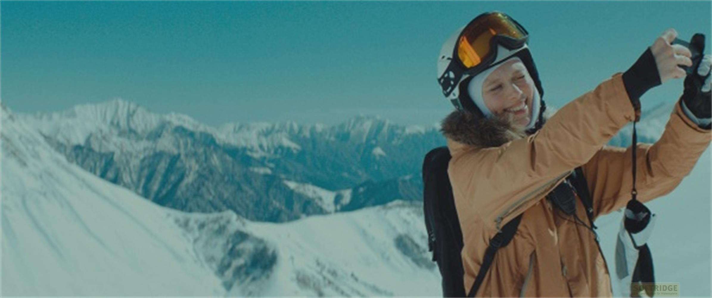 Una sciatrice sorride mentre si scatta un selfie con montagne innevate.