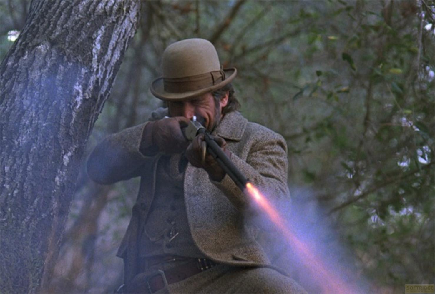 Un uomo con cappello spara un fucile, fiamme escono dalla canna.