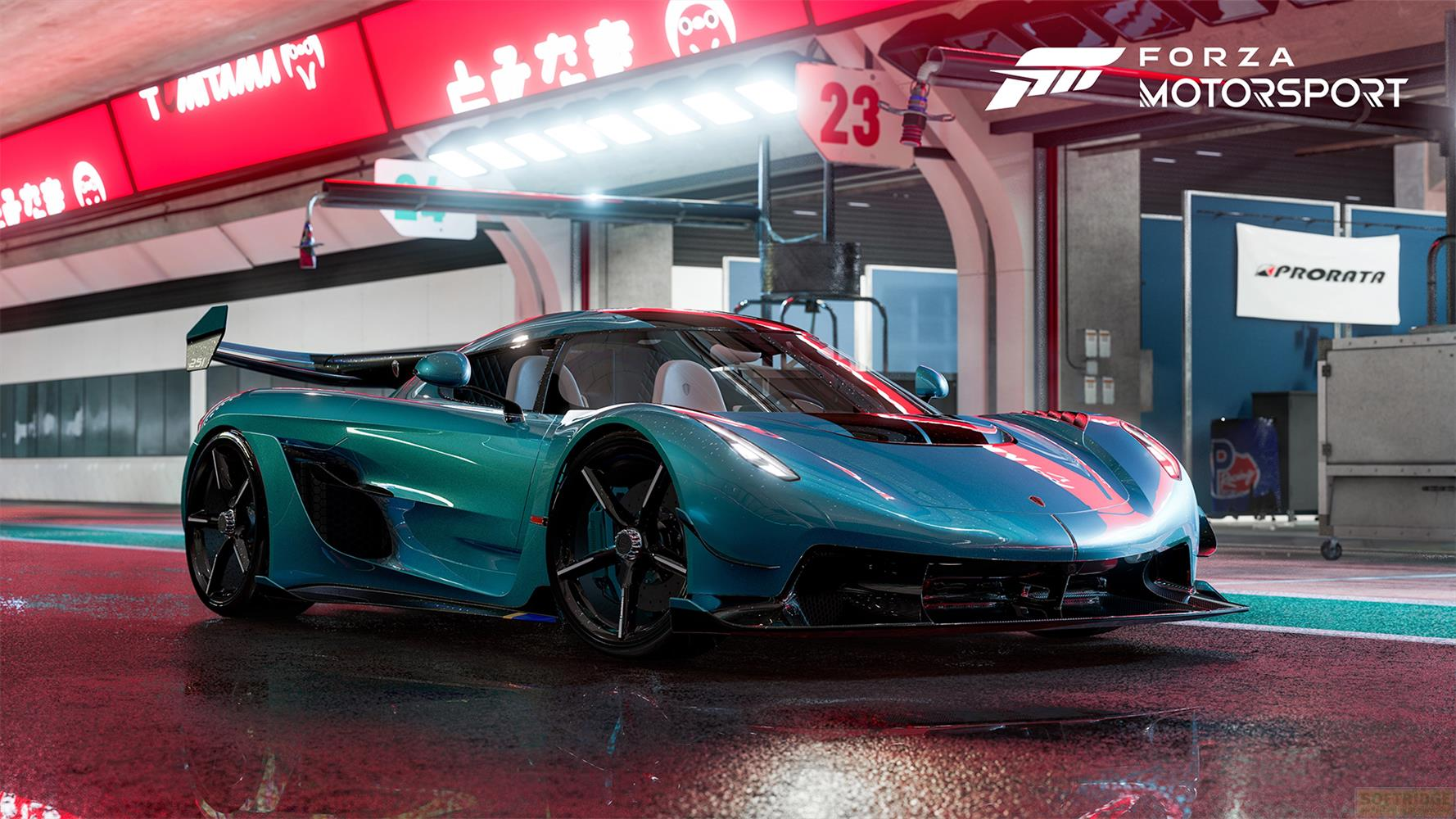 Ein blauer Rennwagen mit roten Streifen steht auf einer nassen Straße vor einer Garage.
