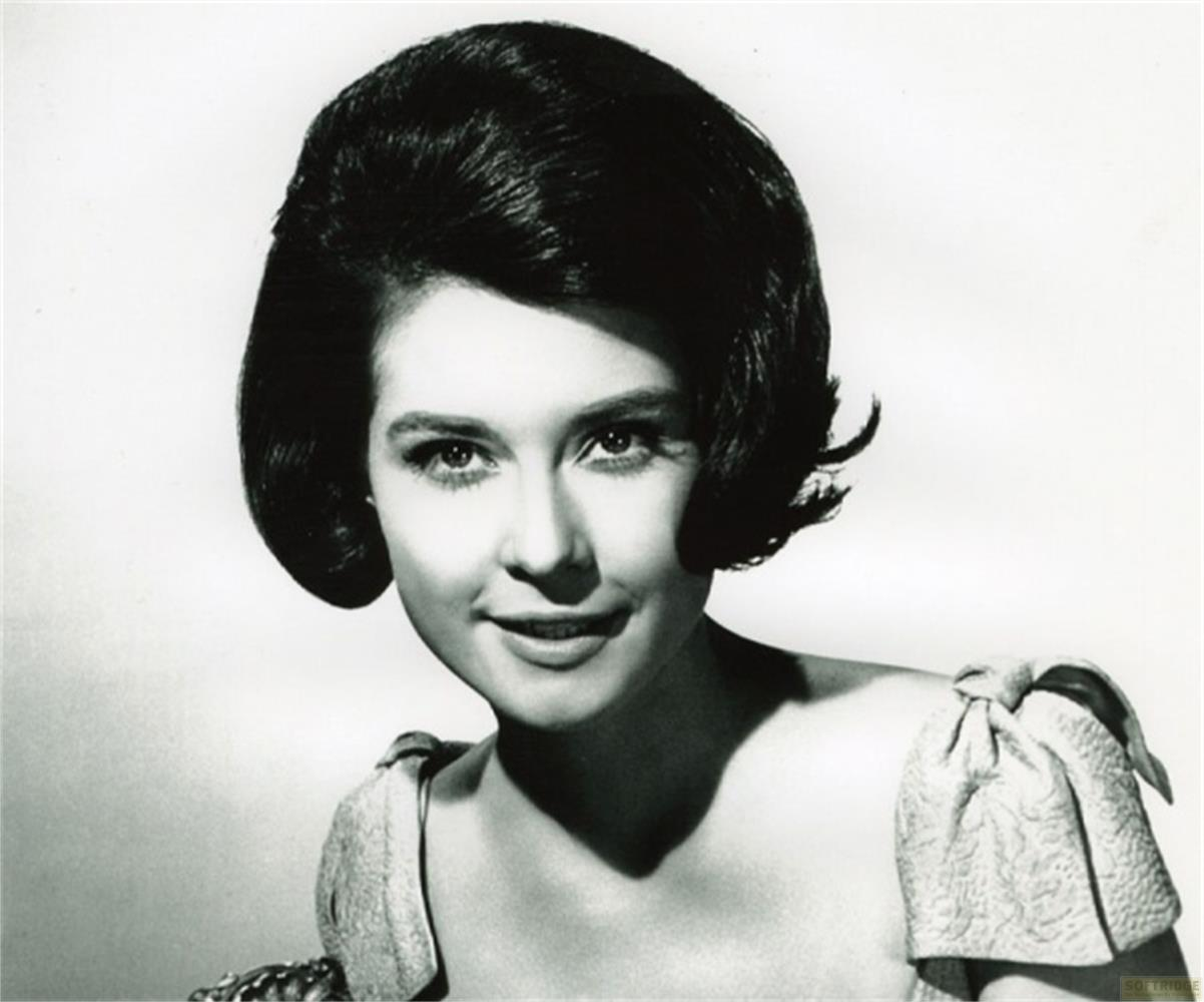 Ritratto in bianco e nero di una donna con capelli corti e voluminosi e un leggero sorriso.
