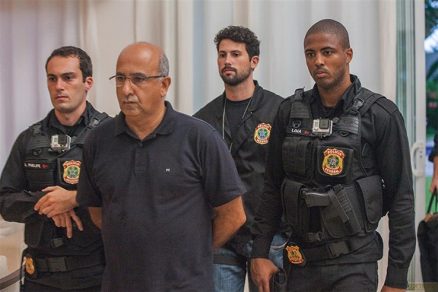 Quattro uomini in uniforme, uno è scortato da due poliziotti.