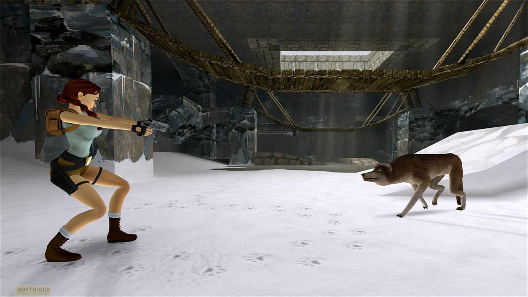 Lara Croft punta una pistola contro un lupo in una grotta innevata con ponti.