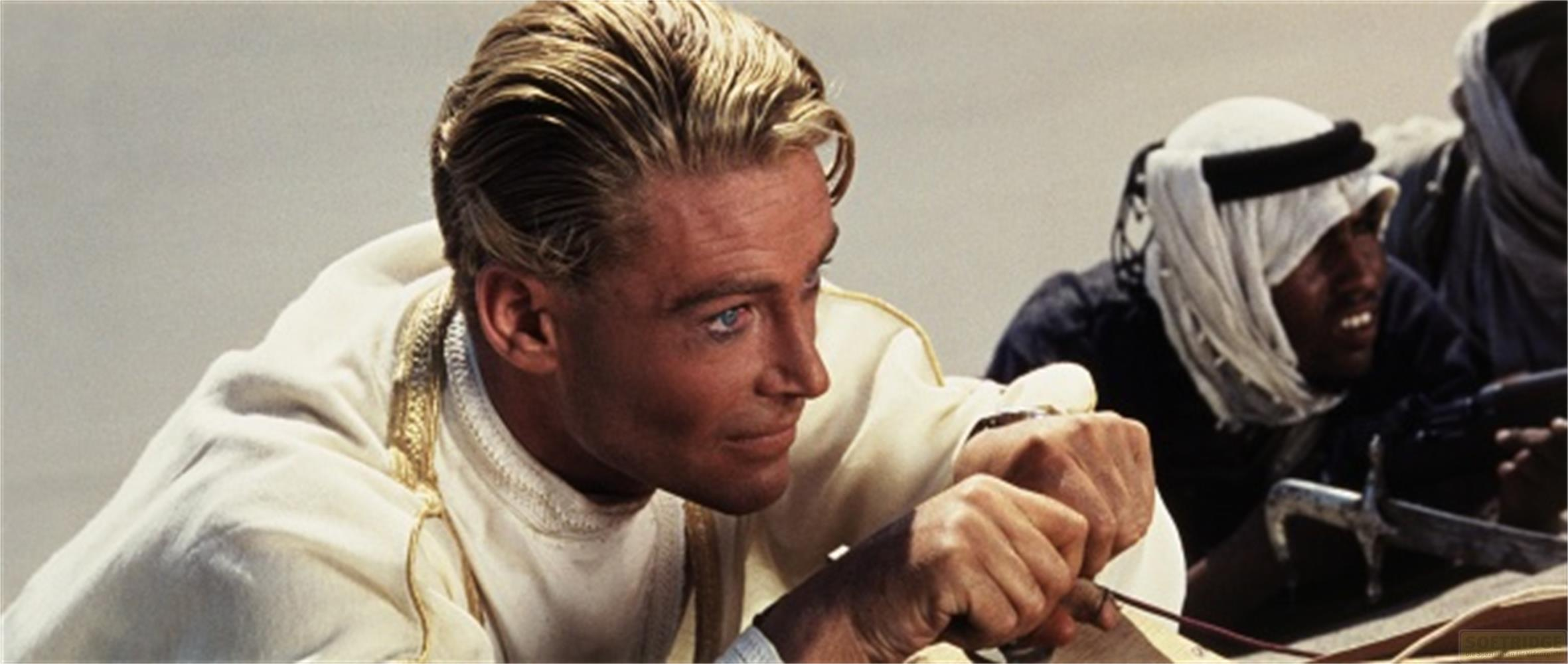 Un uomo in bianco con finiture dorate guarda a destra. Un beduino sullo sfondo.