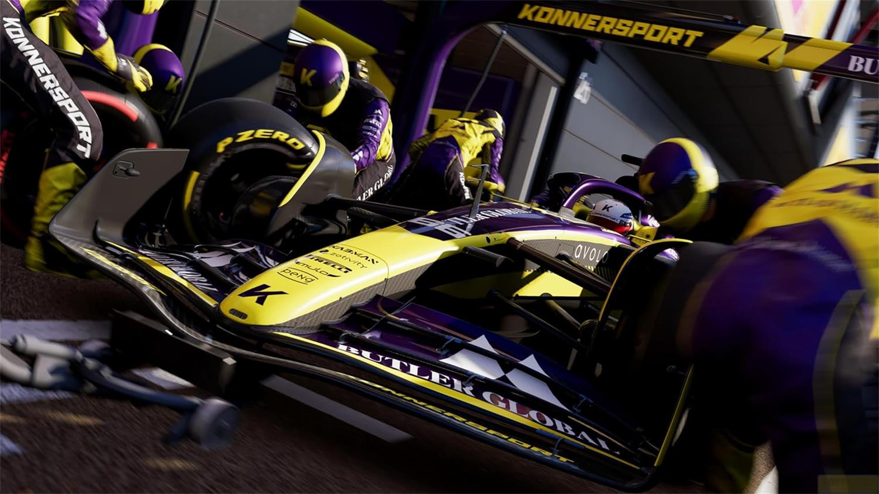 Auto di Formula 1 gialla e viola con meccanici ai box.