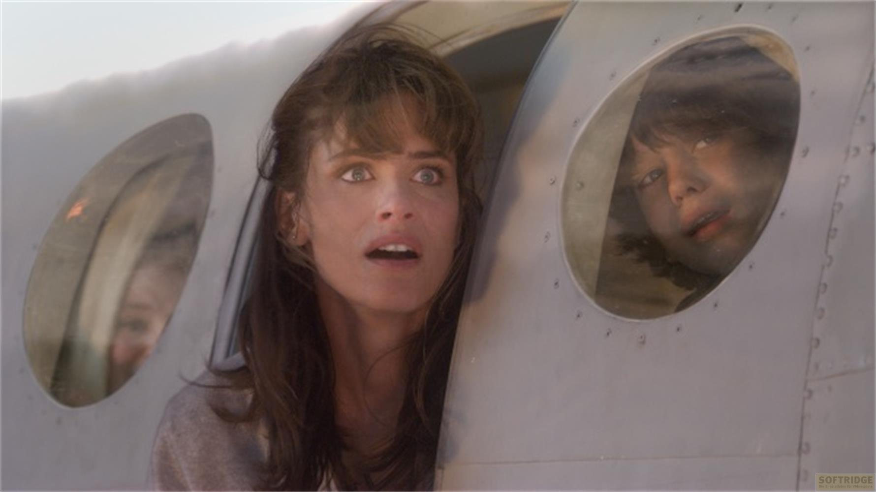 Une femme et un enfant regardent par les fenêtres d'un avion, inquiets.
