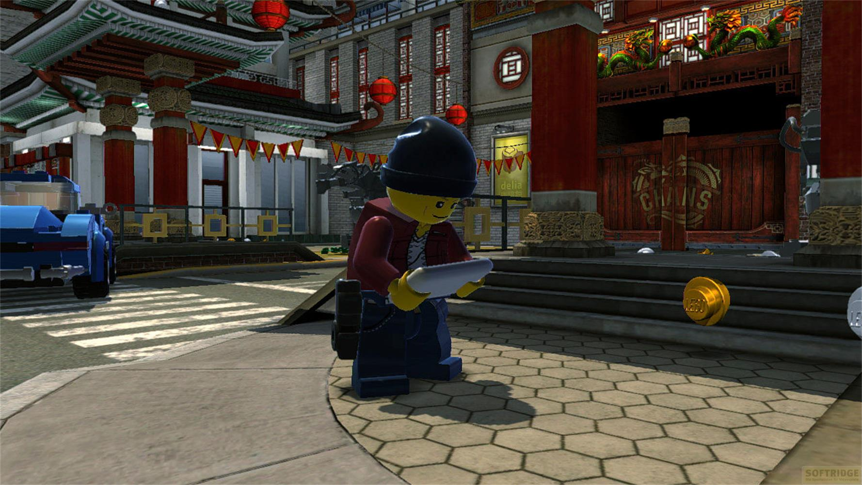 Un personnage Lego avec bonnet et veste tient une tablette dans une ville chinoise.