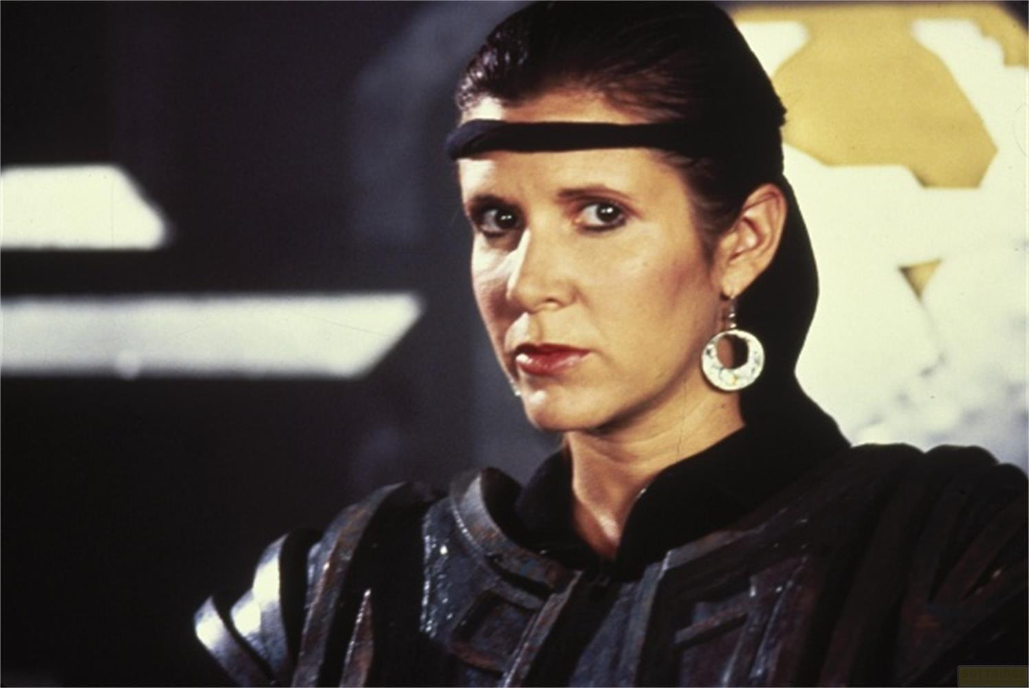 Leia Organa indossa una fascia nera e un'armatura con orecchini.