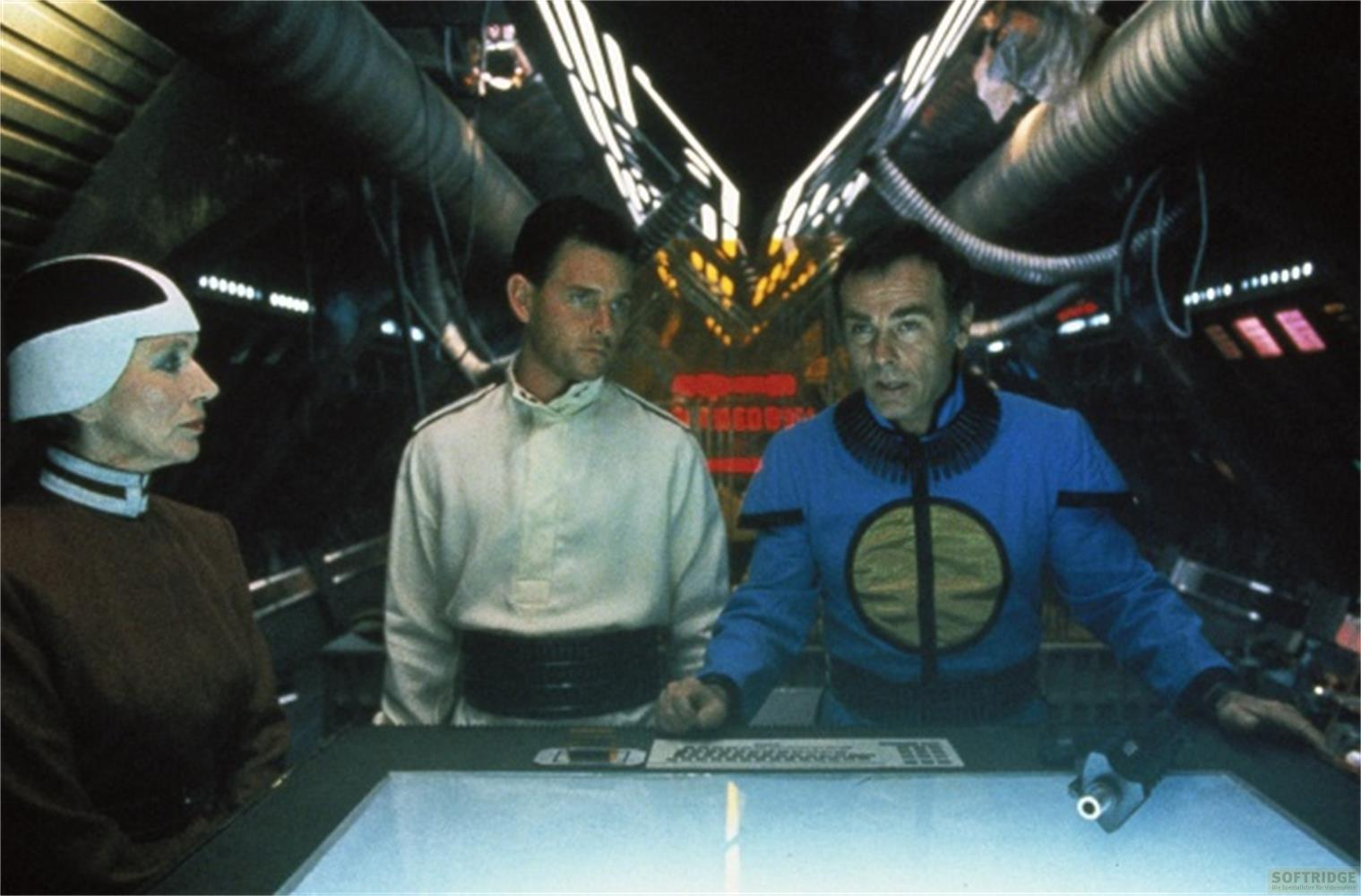 Tre persone in abiti futuristici in una sala di controllo di un'astronave.