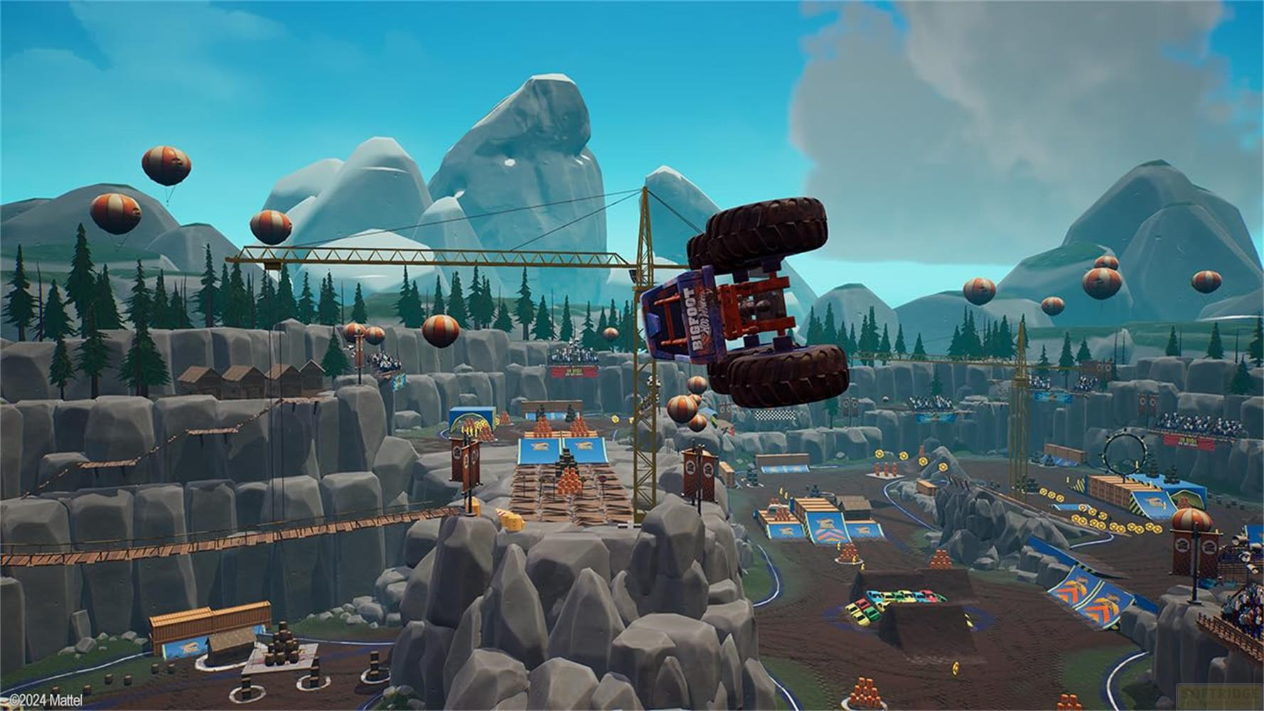 Ein Monstertruck fliegt kopfüber durch die Luft, umgeben von Ballons und einer Berglandschaft.