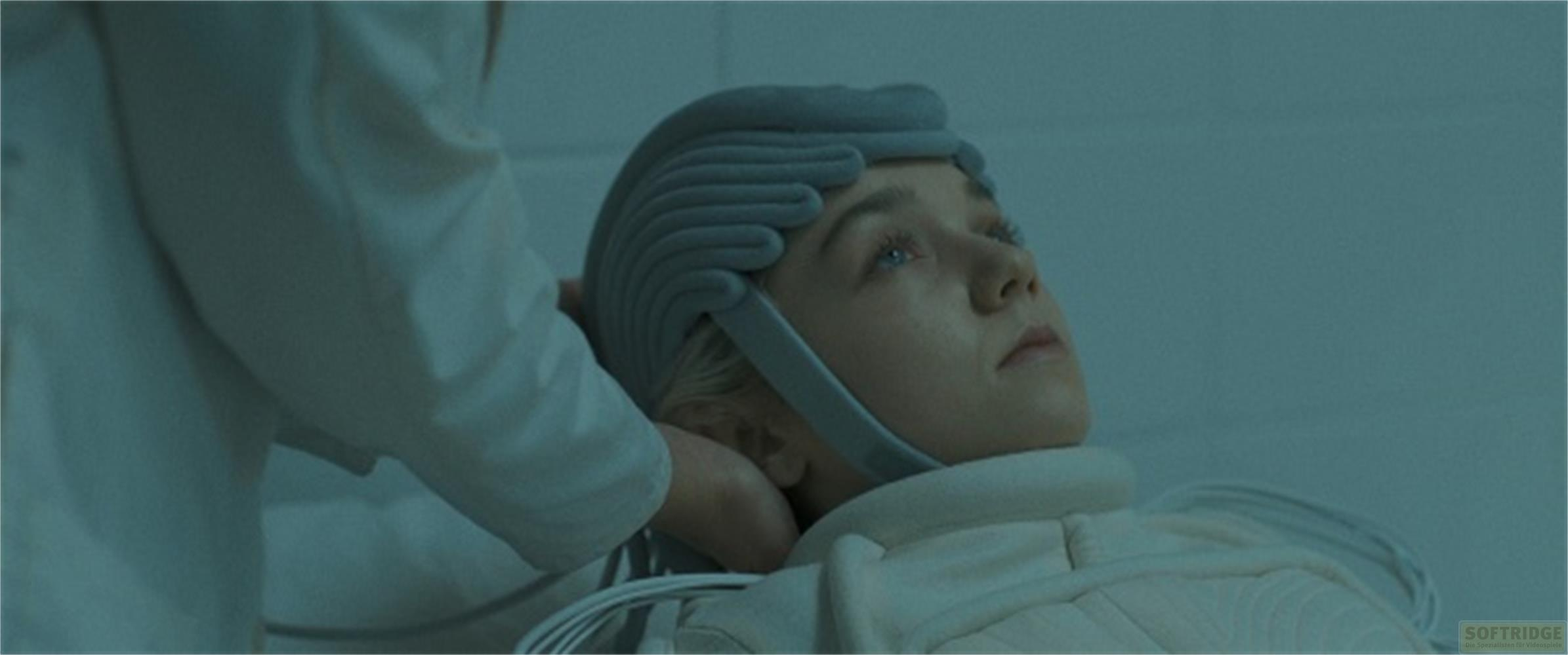 Una ragazza con un casco giace su un letto, una mano sulla testa.