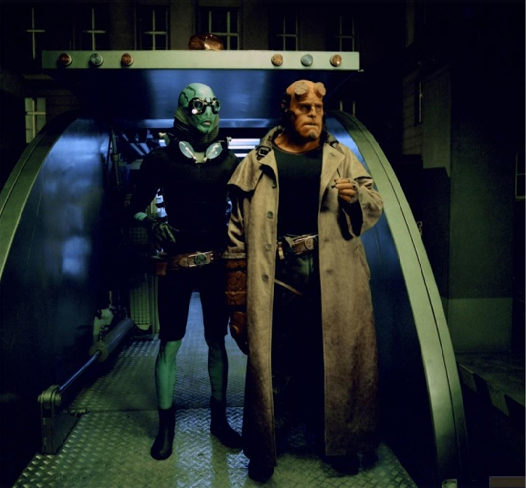 Hellboy et Abe Sapien se tiennent dans un couloir. Hellboy porte un long manteau.