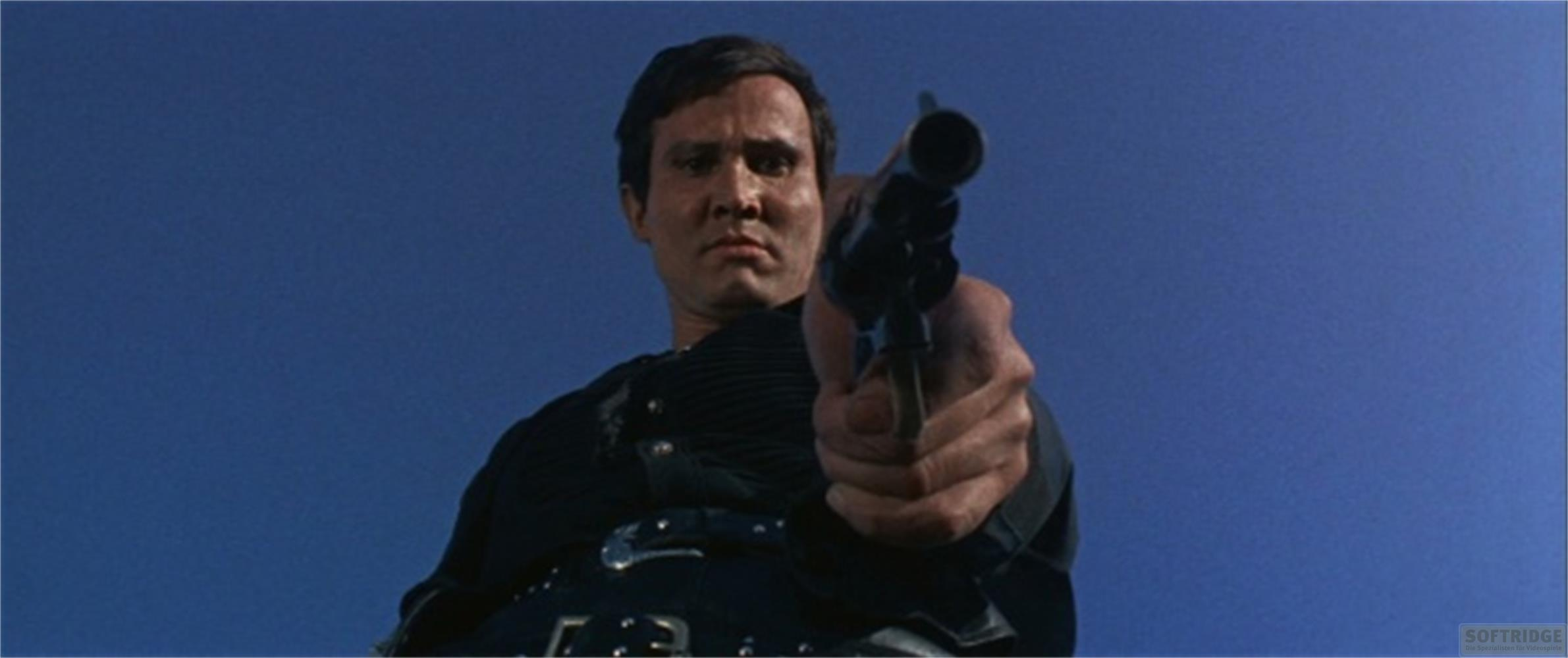 Mann mit Waffe vor blauem Himmel