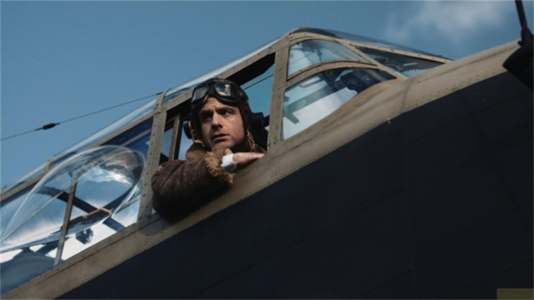 Pilota in giacca di pelle e occhiali guarda fuori dalla cabina di un aereo.