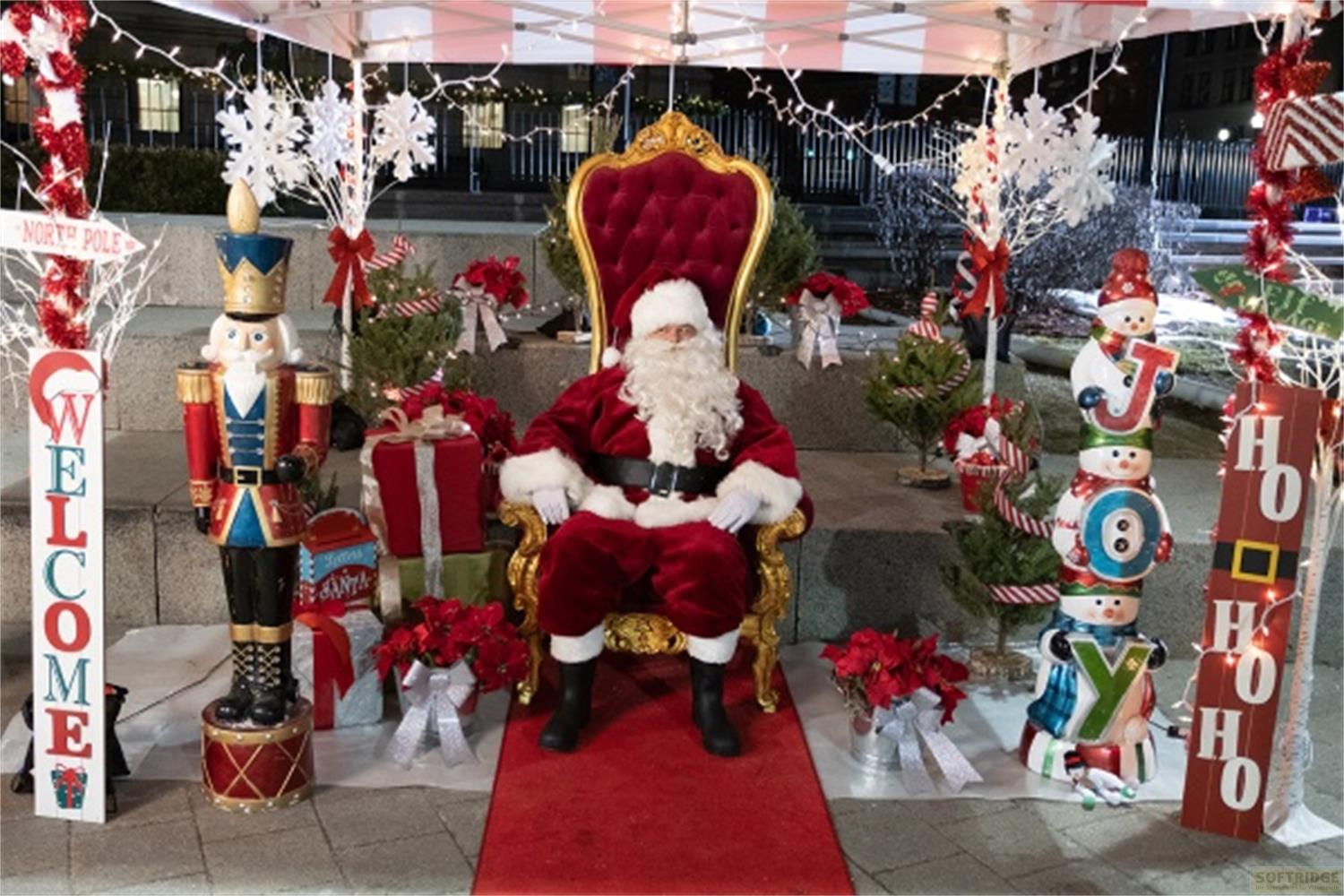 Babbo Natale siede su un trono, con un schiaccianoci, pupazzi di neve e alberi intorno.