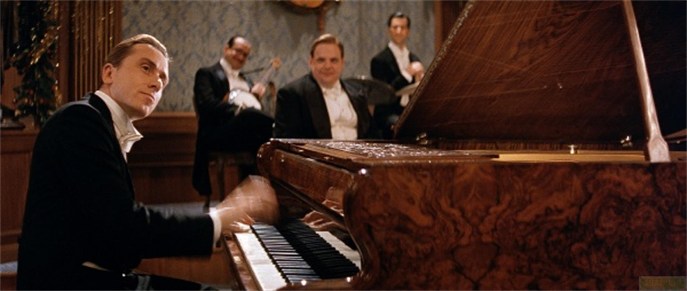 Un pianista suona un pianoforte a coda, accompagnato da musicisti sullo sfondo.