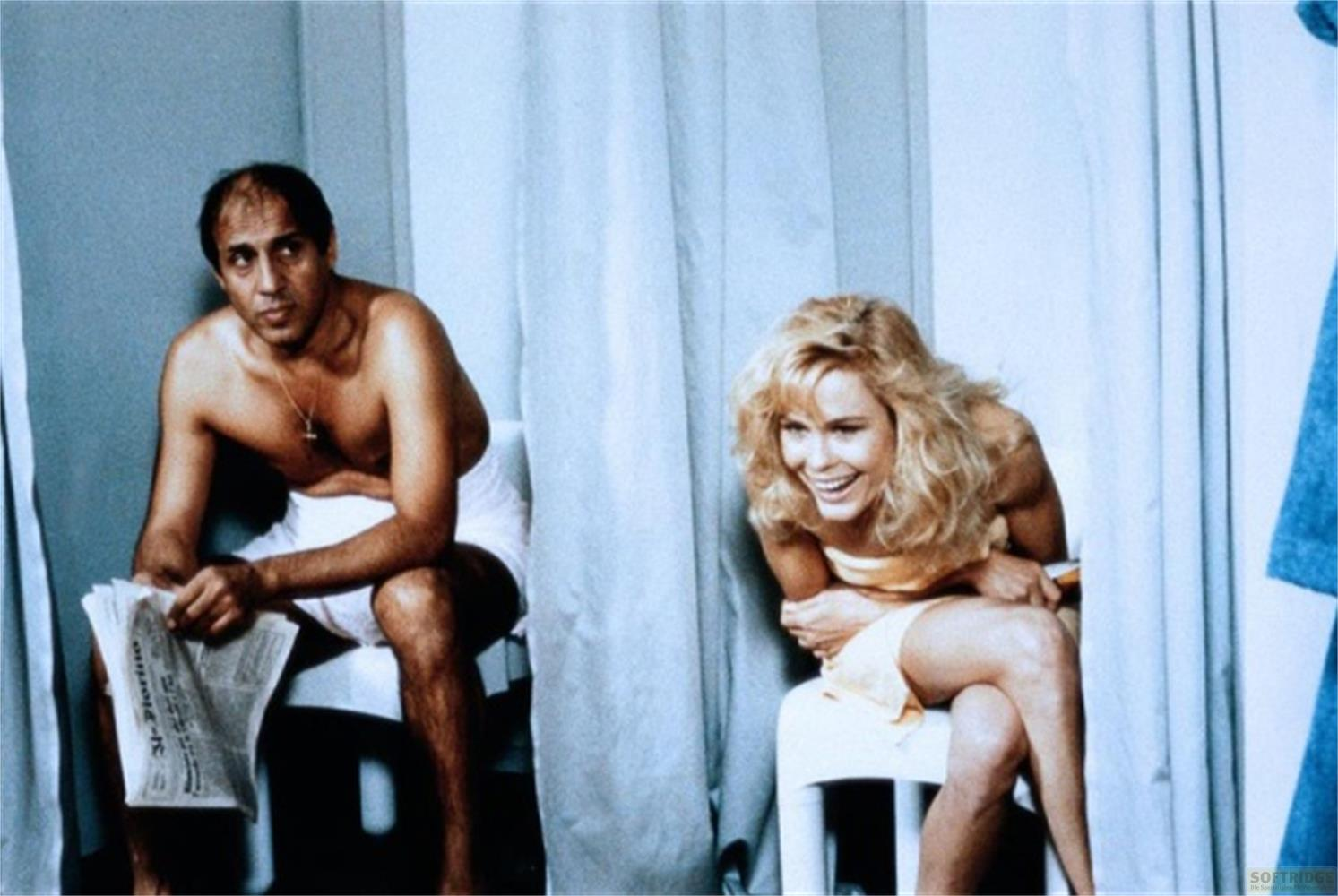Uomo legge giornale, donna ride in bagno.