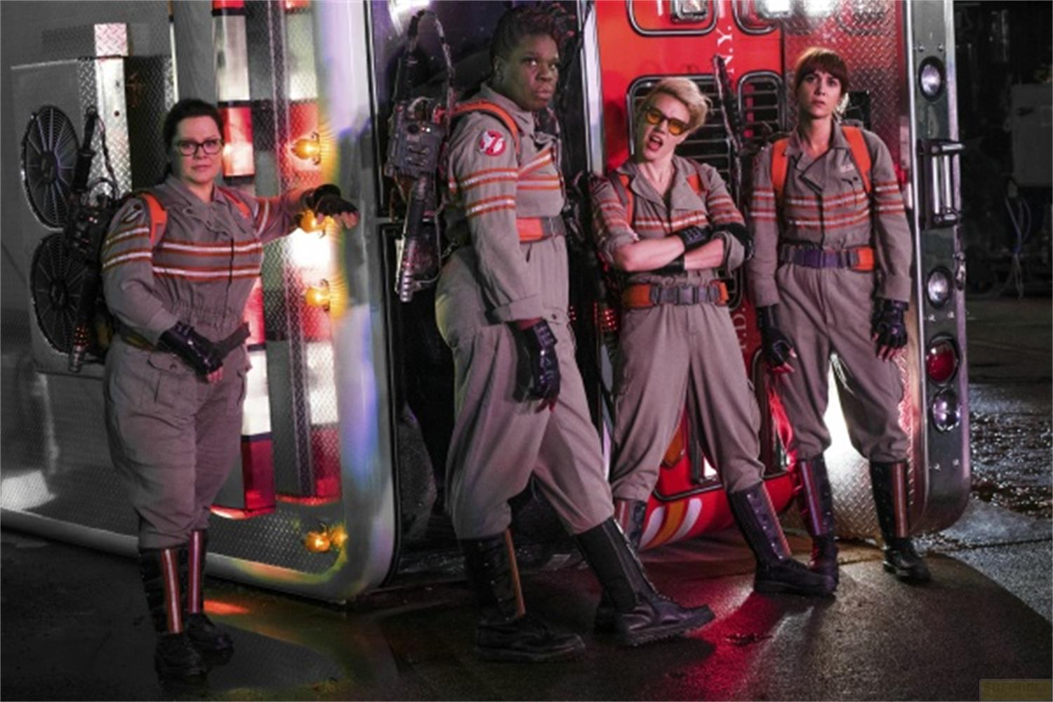 Quattro donne in costume da Ghostbusters davanti a un camion dei pompieri rovesciato.