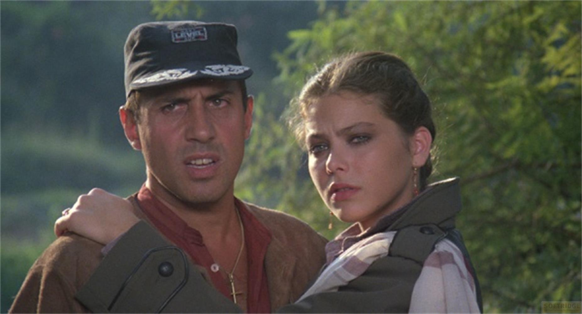 Un uomo con cappello e una giovane donna guardano preoccupati la telecamera.