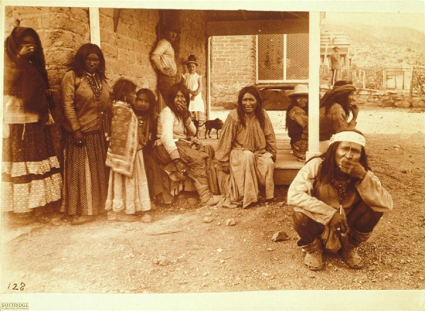 Un gruppo di nativi americani posa davanti a un edificio in mattoni.