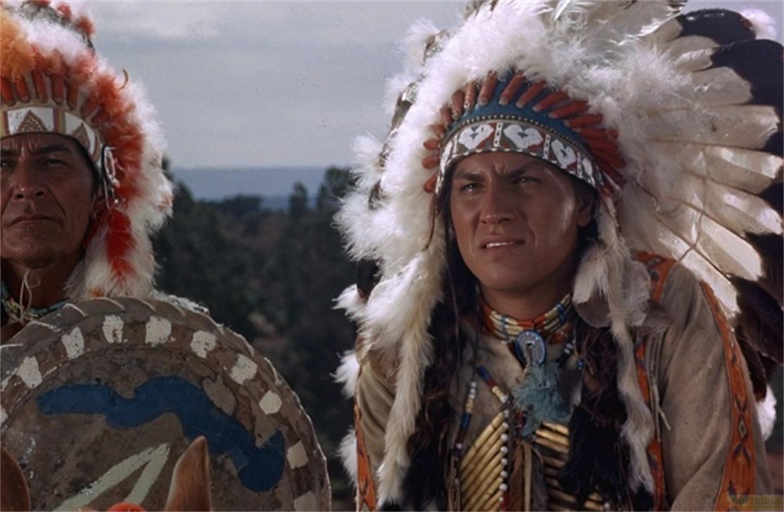 Due nativi americani con copricapi piumati, uno tiene uno scudo decorato.