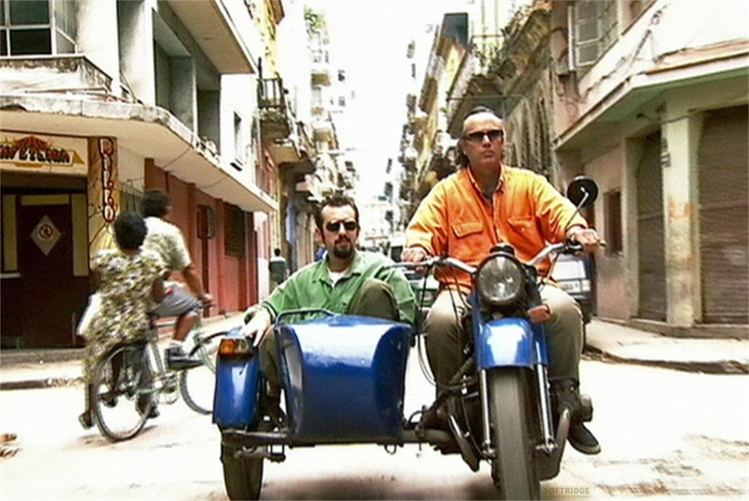 Due uomini su una moto con sidecar percorrono una strada dell'Avana.