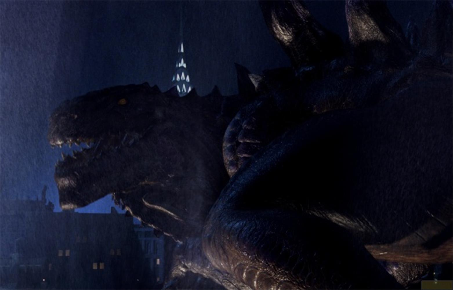 Godzilla se tient sous la pluie, la nuit, devant un gratte-ciel.