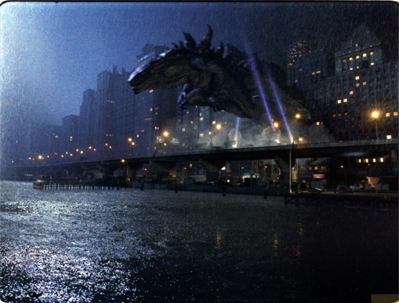 Godzilla plane au-dessus d'une ville pluvieuse avec des lumières et un pont.
