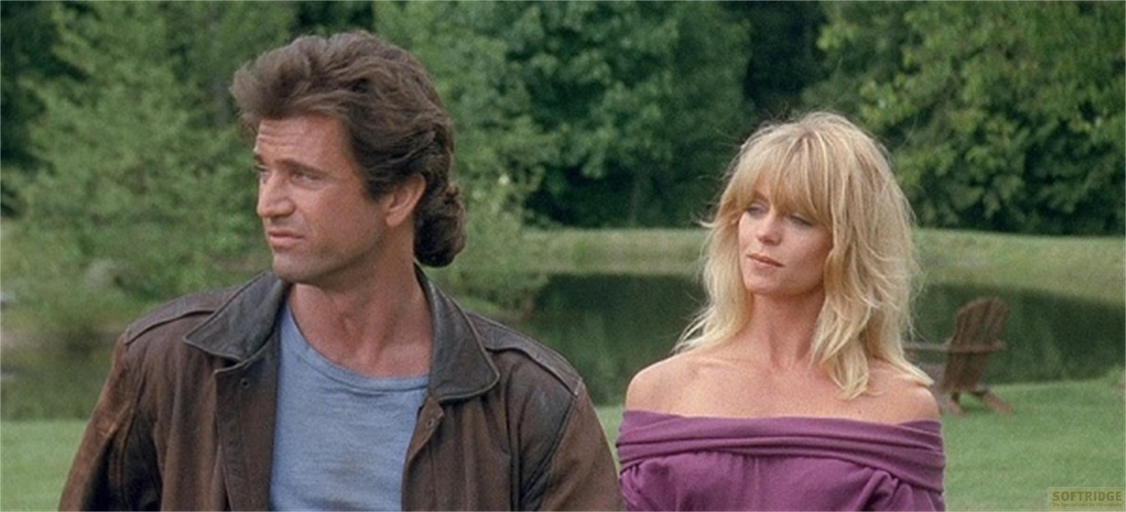 Uomo con giacca di pelle marrone e donna con top viola all'aperto.