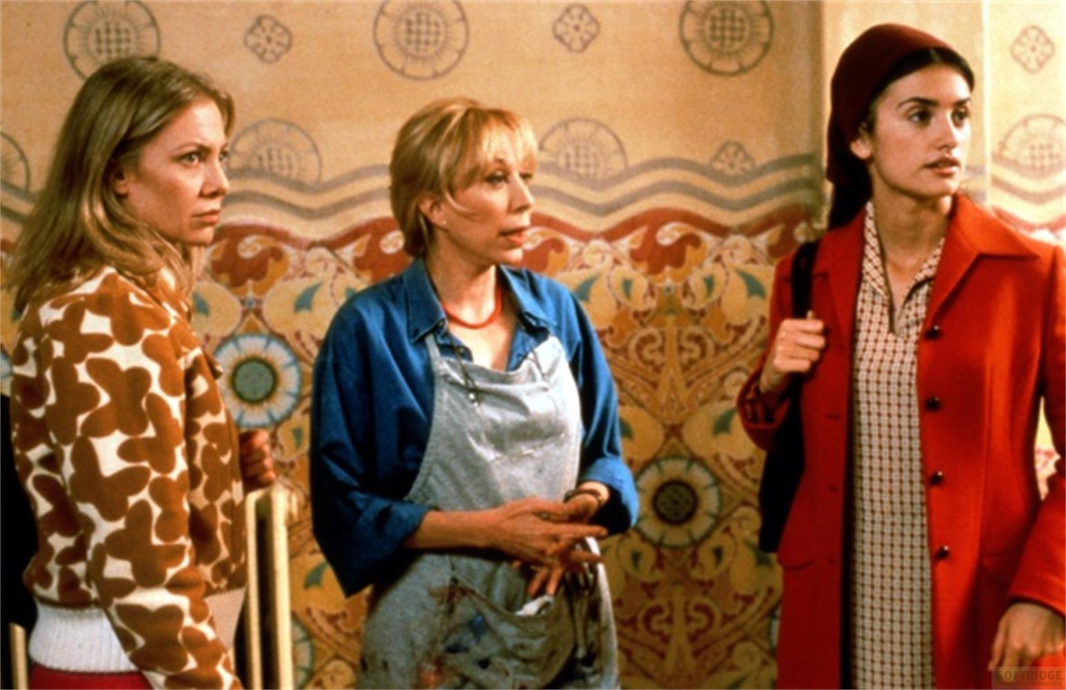 Tre donne davanti a un muro decorato. Una indossa un maglione a farfalle.