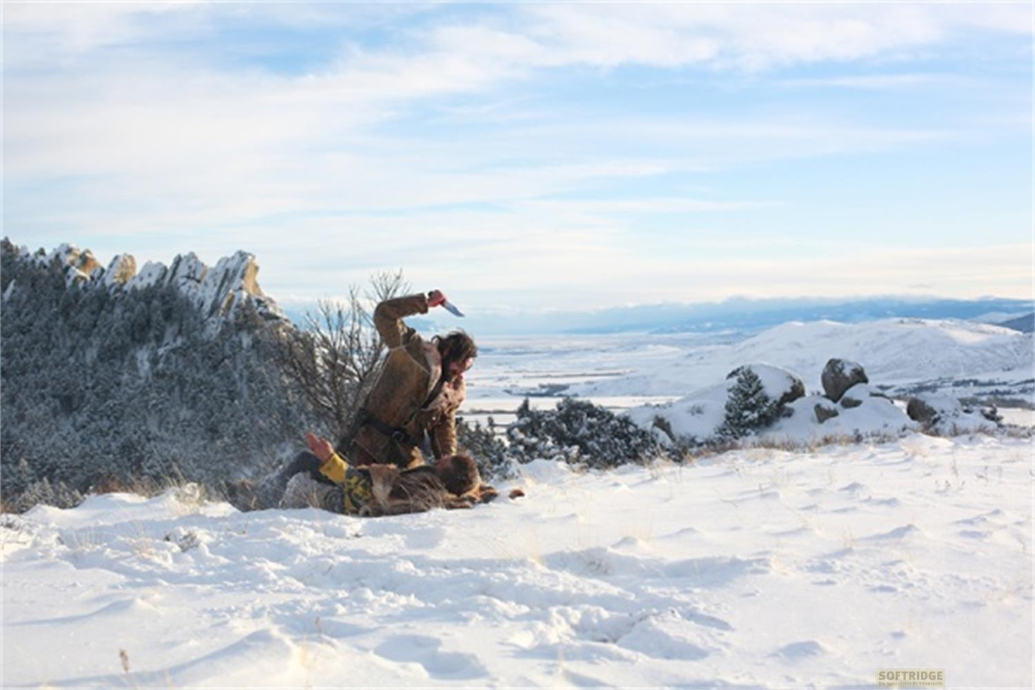 Due uomini combattono nella neve. Uno tiene un coltello alla gola dell'altro.