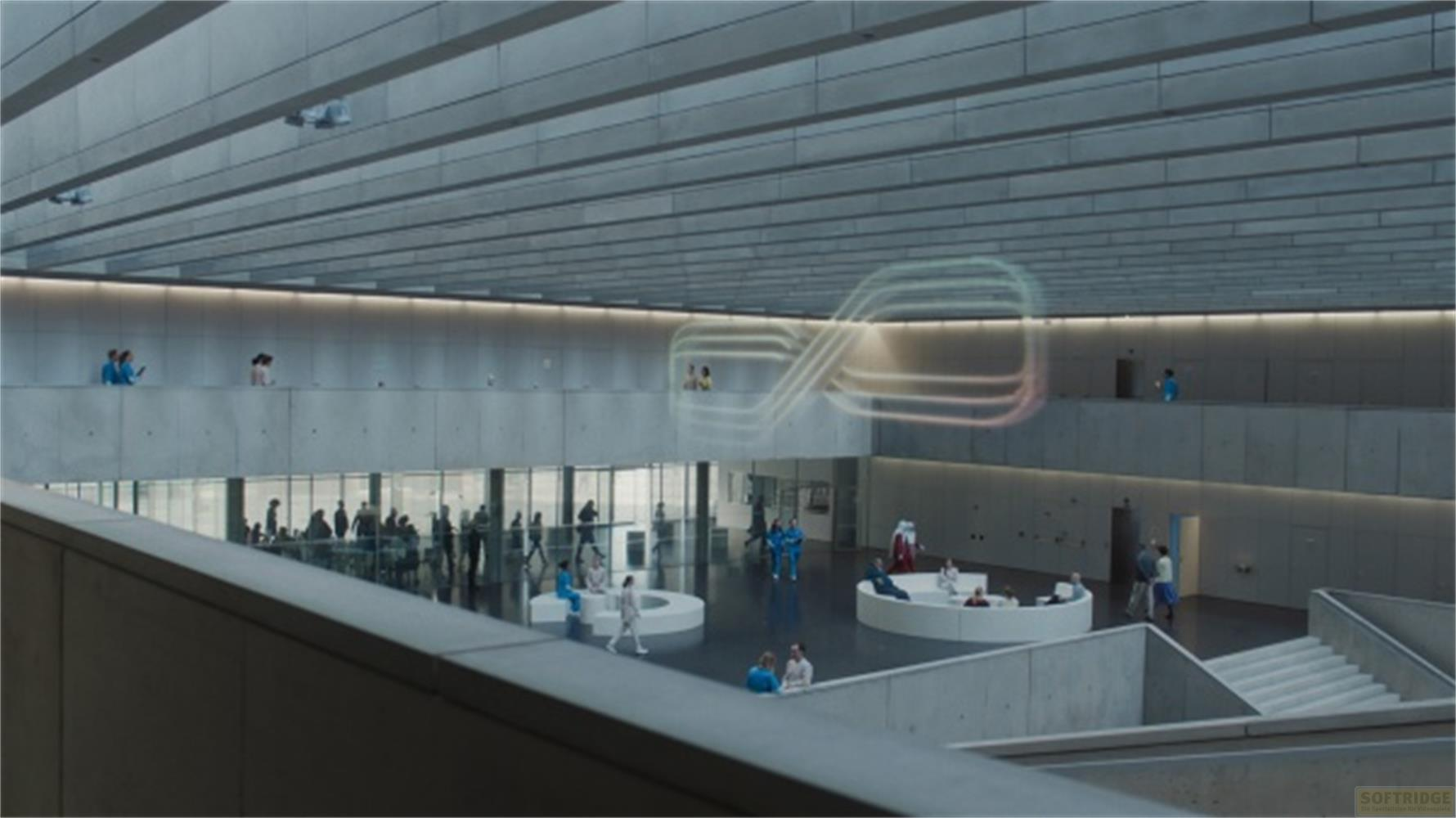 Sala moderna con persone su più livelli e un'installazione luminosa fluttuante.