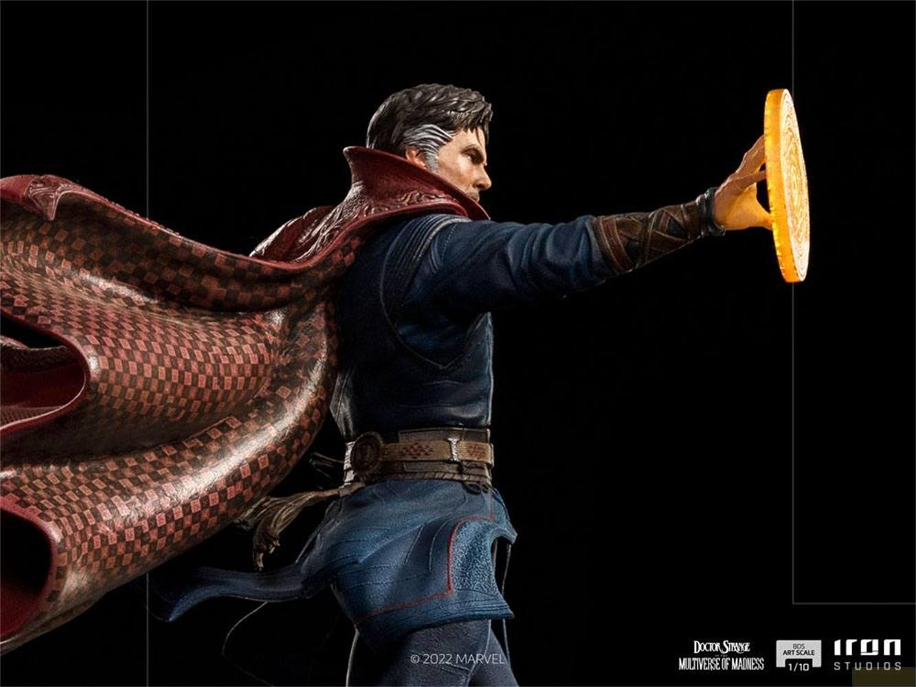 Una figura di Doctor Strange in costume blu con mantello rosso, tiene un disco luminoso.