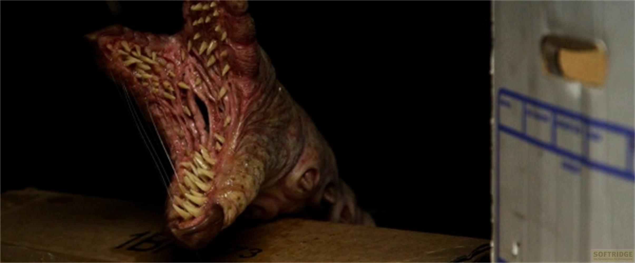 Una creatura grottesca con molti denti aguzzi emerge da una scatola.