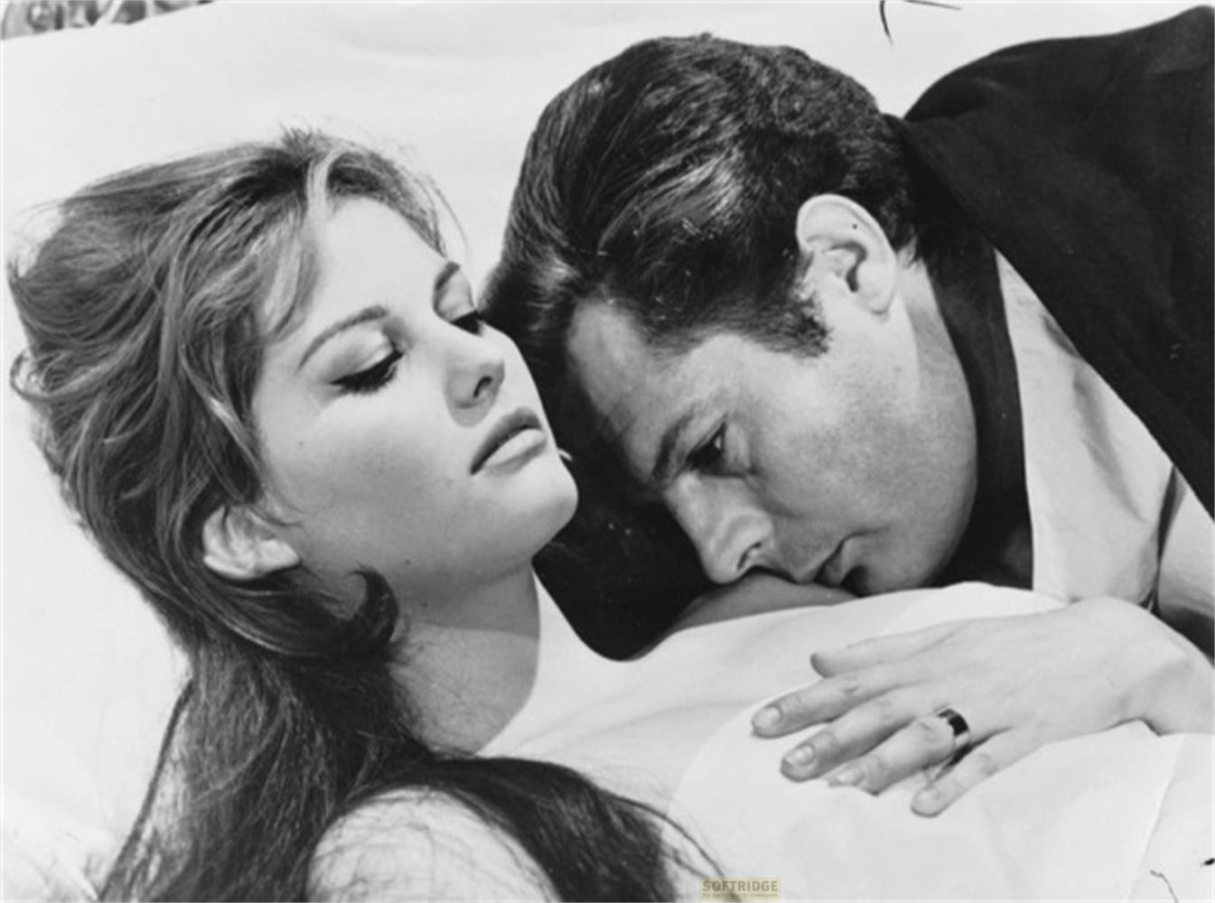 Uomo bacia donna sul collo, foto B/N.