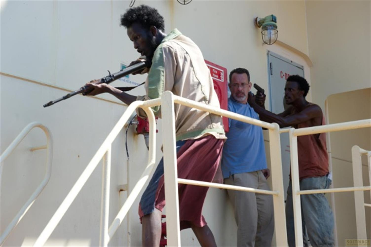 Uomo con fucile su nave, Tom Hanks tiene pistola.